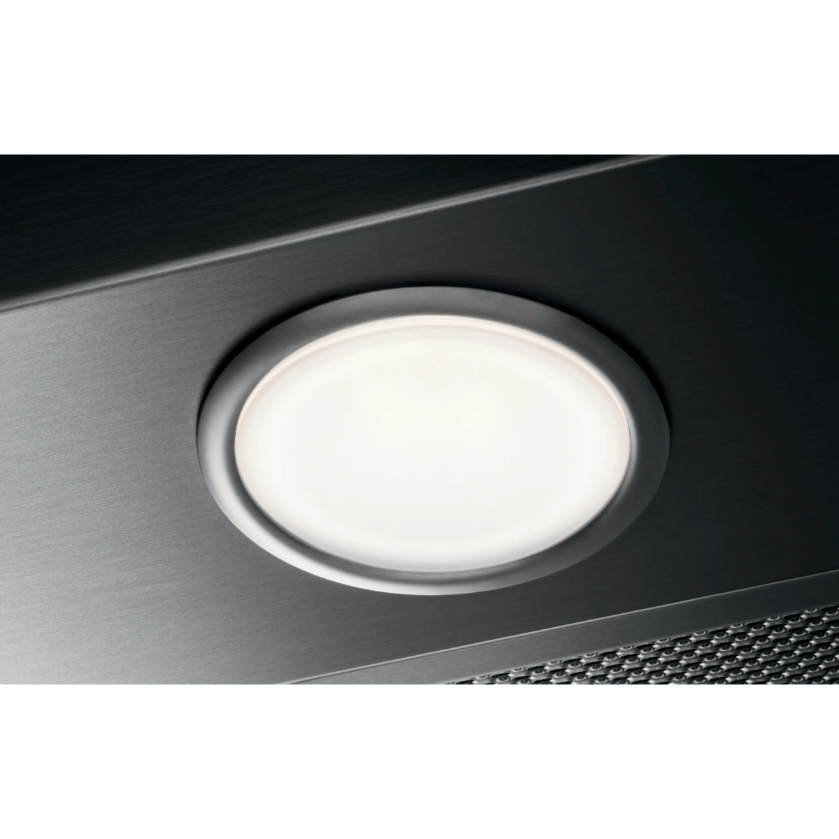 Una lámpara LED redonda e iluminada está empotrada en una superficie metálica oscura con un filtro de malla.