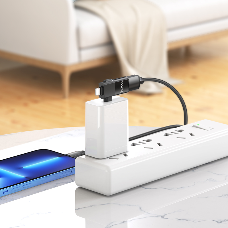 Una regleta blanca con un cargador y un teléfono inteligente azul conectado en una mesa.
