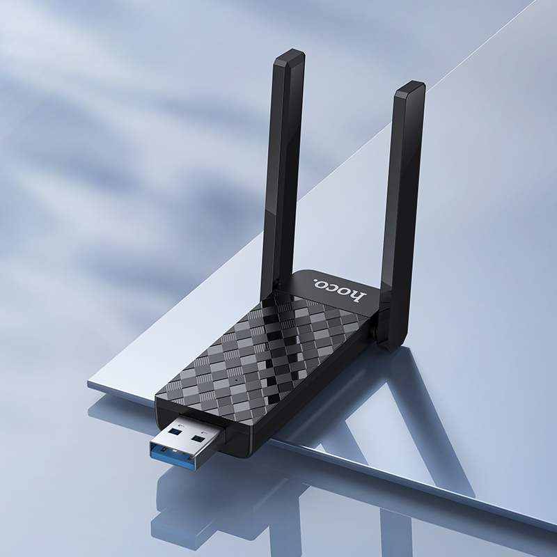 Adaptador Wi-Fi USB negro con dos antenas y logo Hoco en superficie brillante.