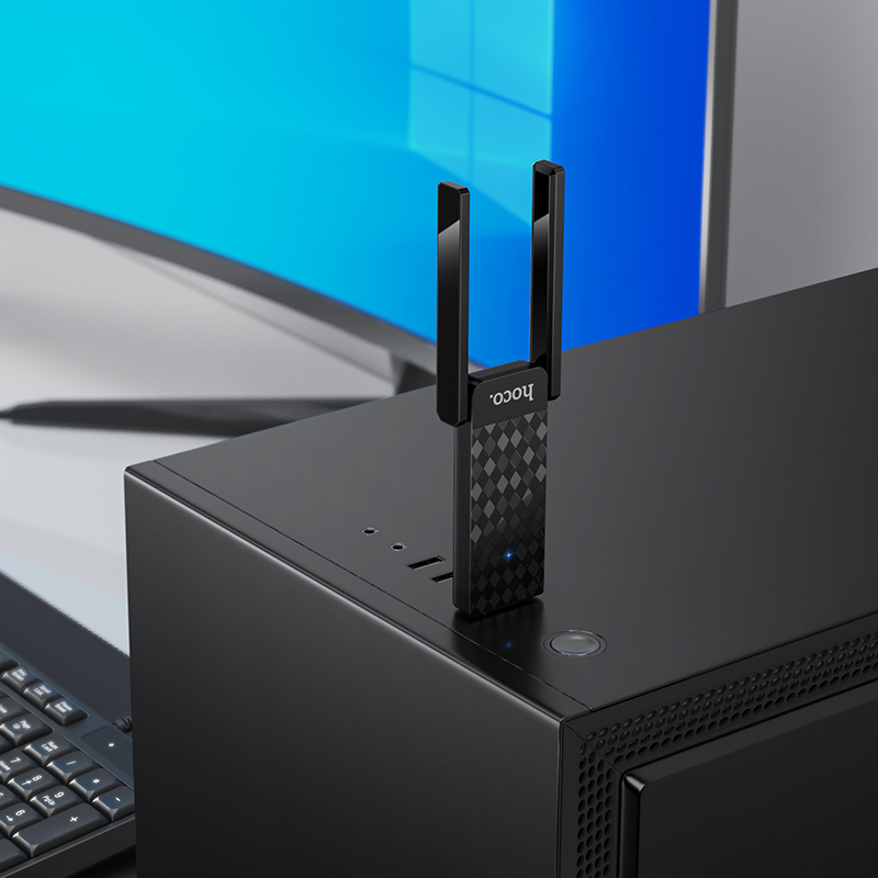 Un adaptador USB Wi-Fi negro con dos antenas conectado a la parte superior de una torre.