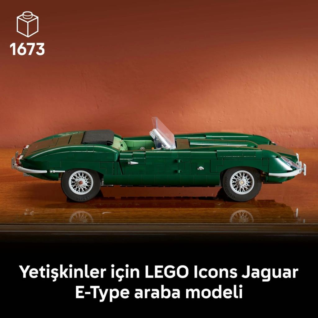 Un modelo de coche LEGO Icons Jaguar E-Type verde en una mesa de madera contra una pared naranja.