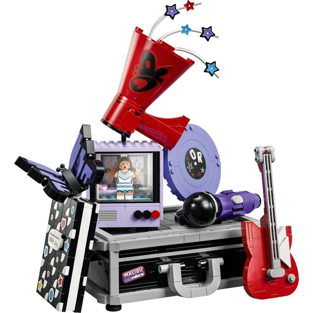 Kırmızı megafon, mor televizyon, plak, mikrofon, gitar ve siyah kitap içeren Lego seti.