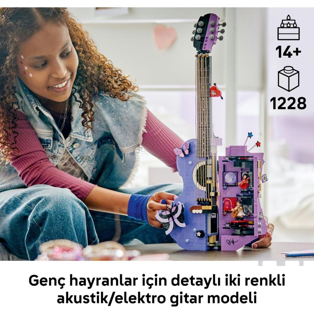 Genç kız, içinde odalar bulunan detaylı bir Lego gitar modelini tutarak gülümsüyor.