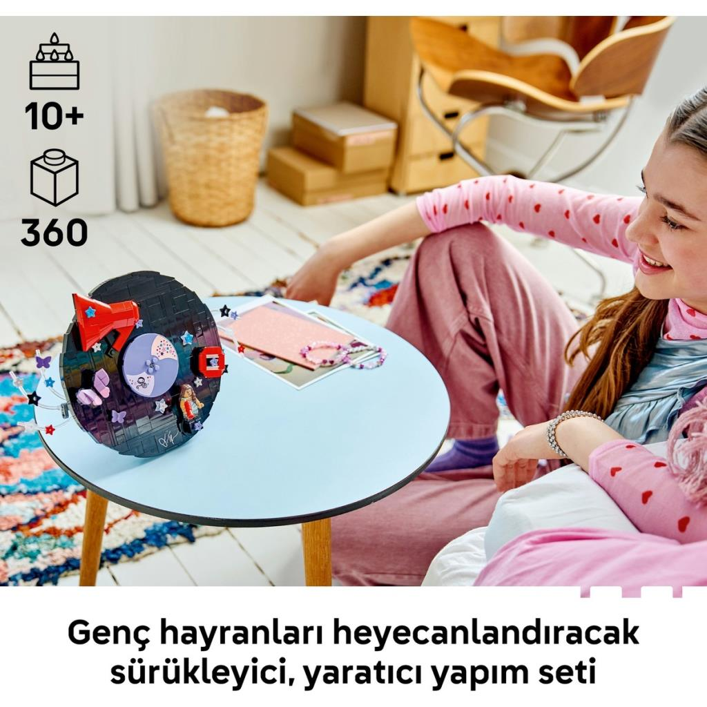 Una giovane ragazza costruisce un set LEGO posizionato su un tavolo azzurro.