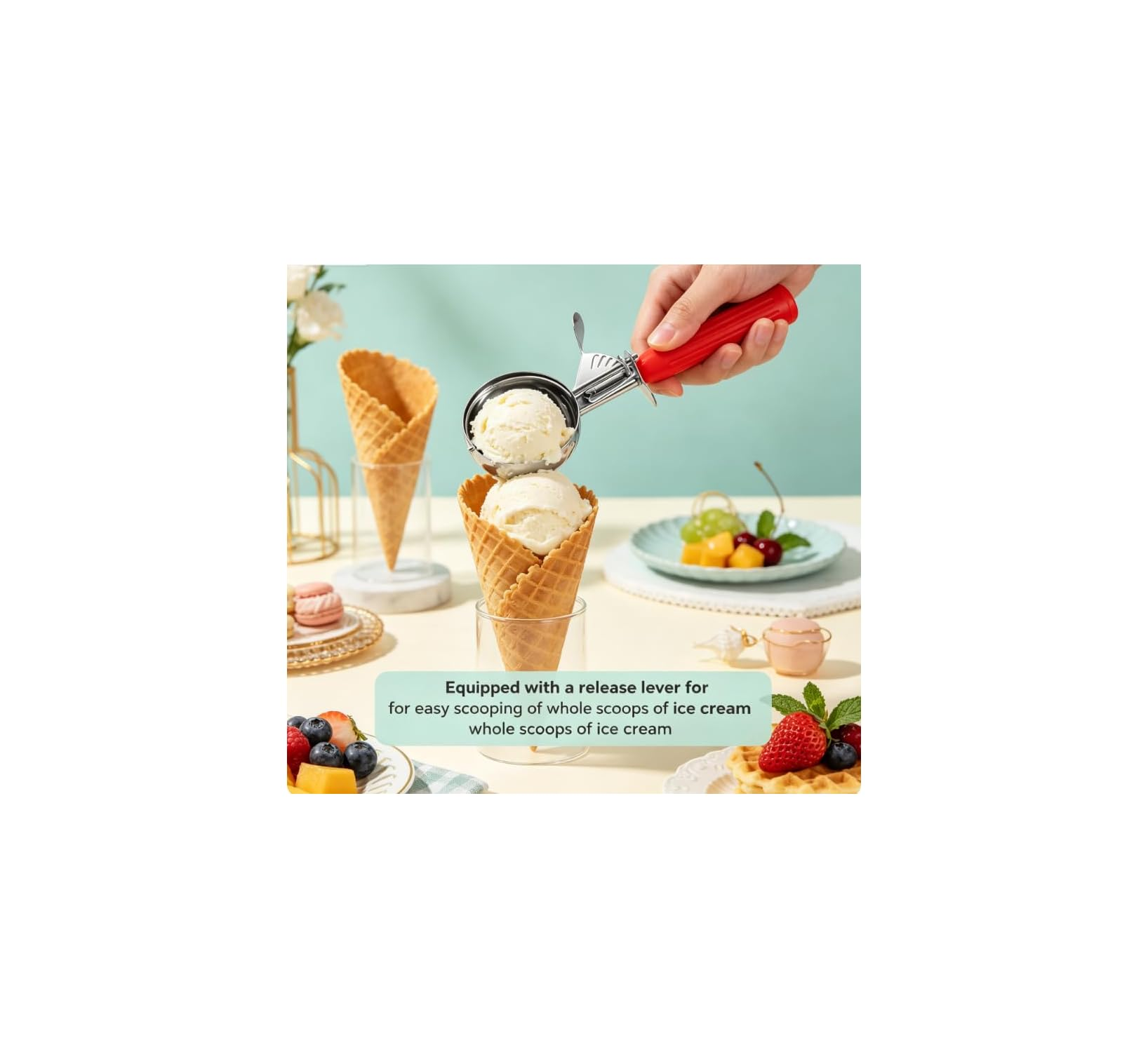 Eine Hand benutzt einen roten Eiskugelportionierer, um eine Kugel Eis in eine Waffeltüte zu geben.