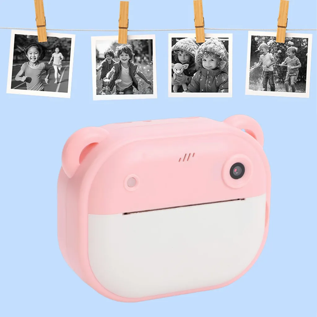 Rosa Kinderkamera mit Bärenohren und vier schwarz-weißen Fotos, die an einer Leine hängen, vor hellblauem Hintergrund.