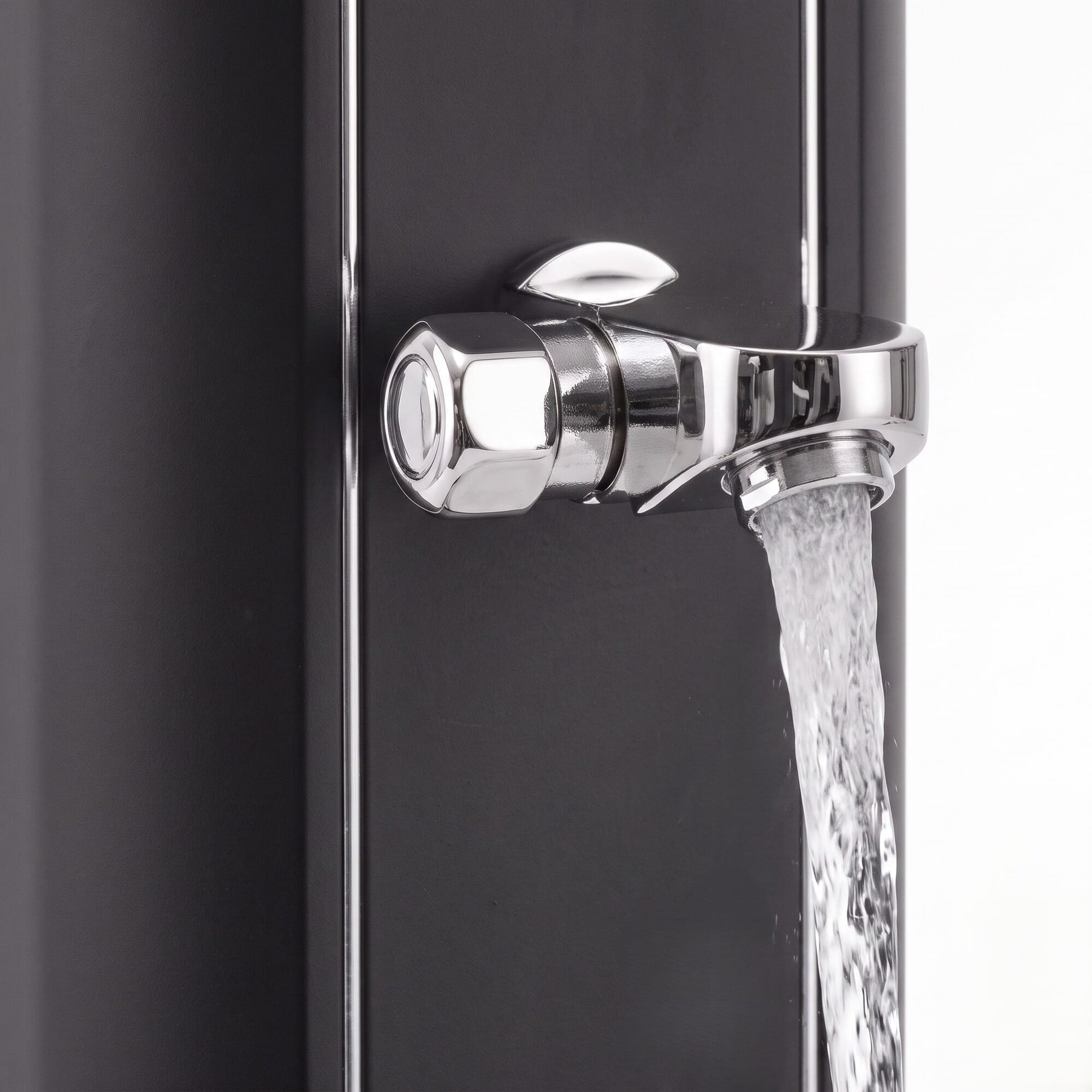Un grifo cromado brillante está unido a una pared negra mate, con agua fluyendo de él.