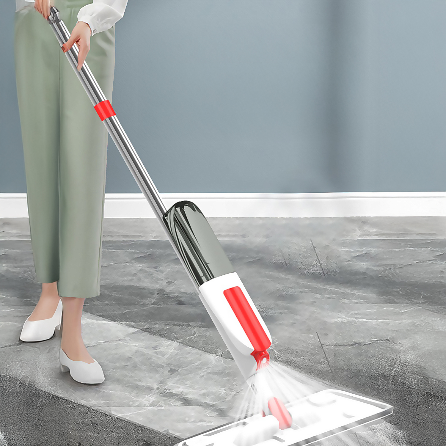Una persona usa una fregona con spray blanca y roja para limpiar el suelo.