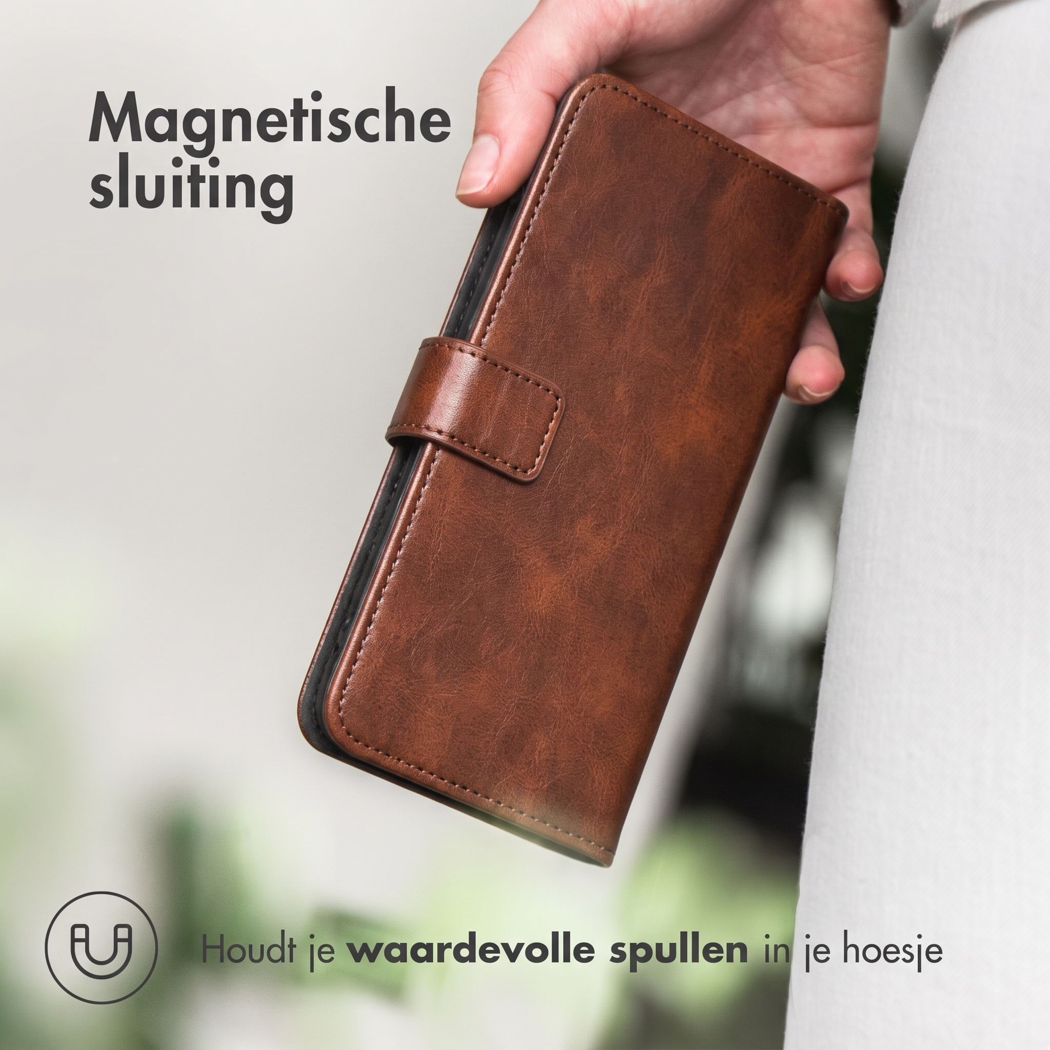 Hand houdt bruine leren telefoonhoes met magnetische sluiting. Tekst.