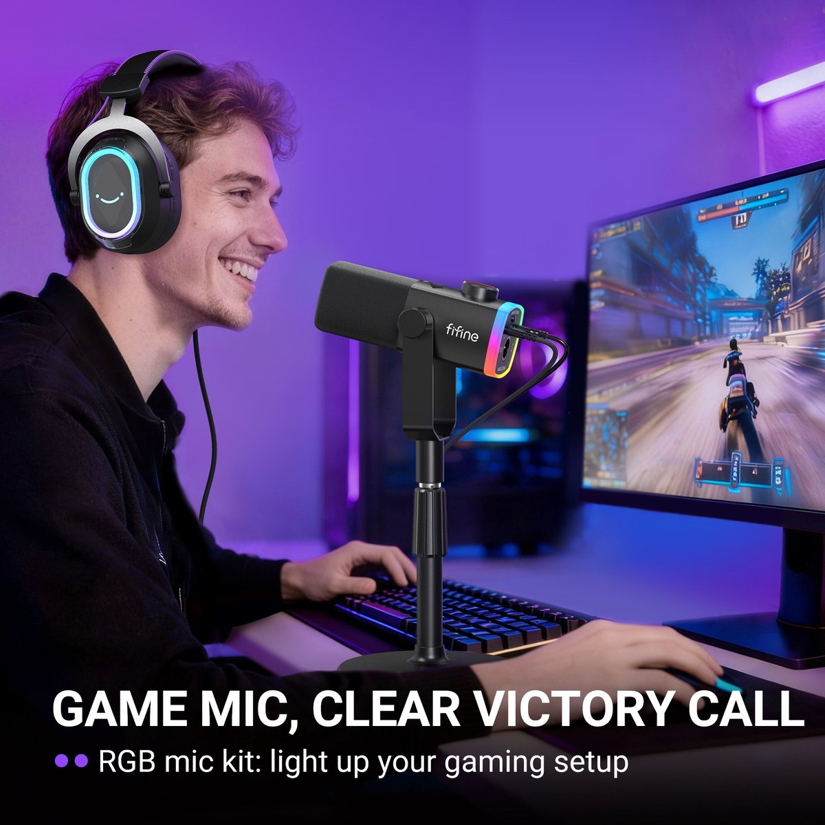 Un joueur souriant portant un casque RGB est assis à un bureau avec un micro Fifine et un moniteur.