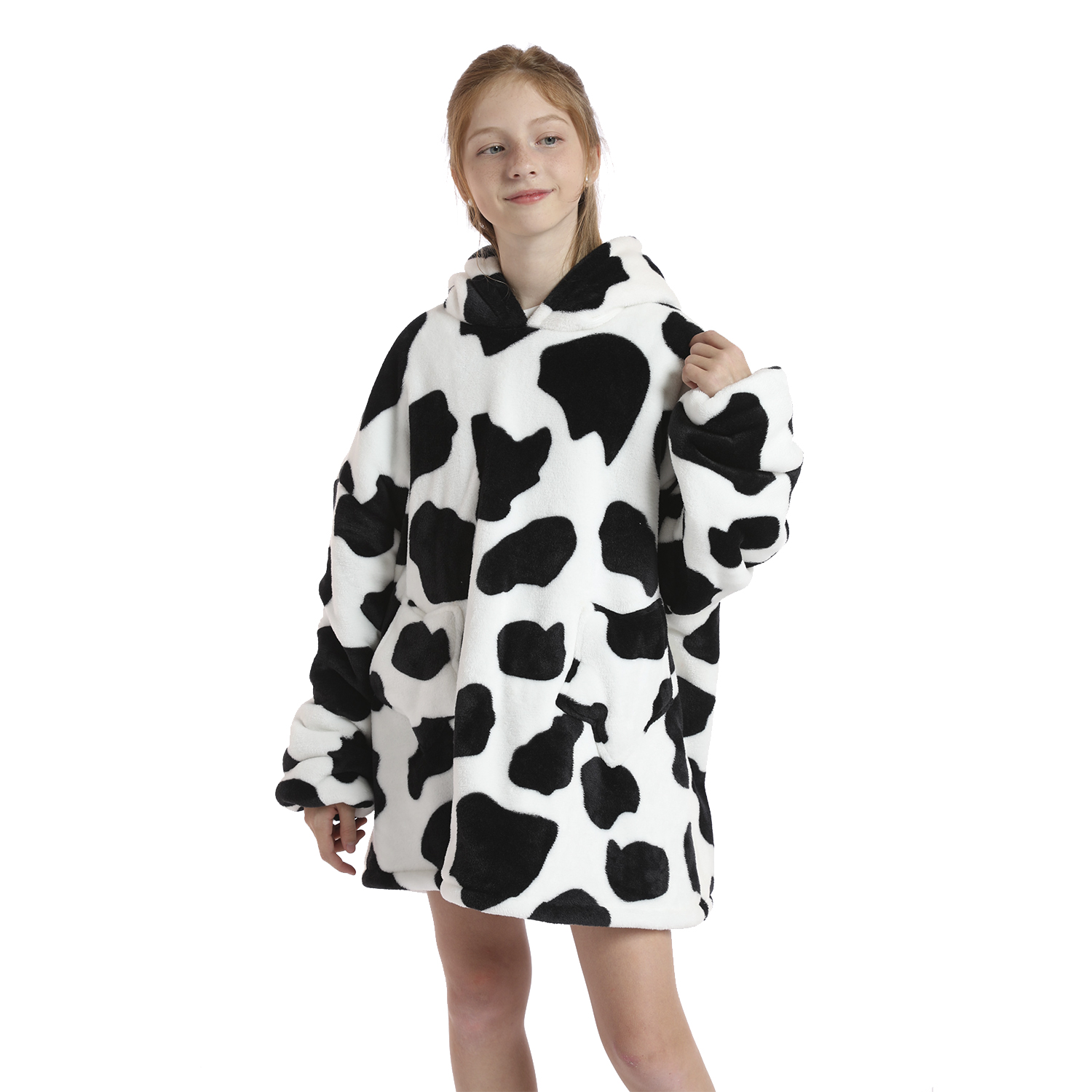 Una niña con cabello castaño rojizo lleva una sudadera con capucha de peluche con estampado de vaca sobre fondo blanco.