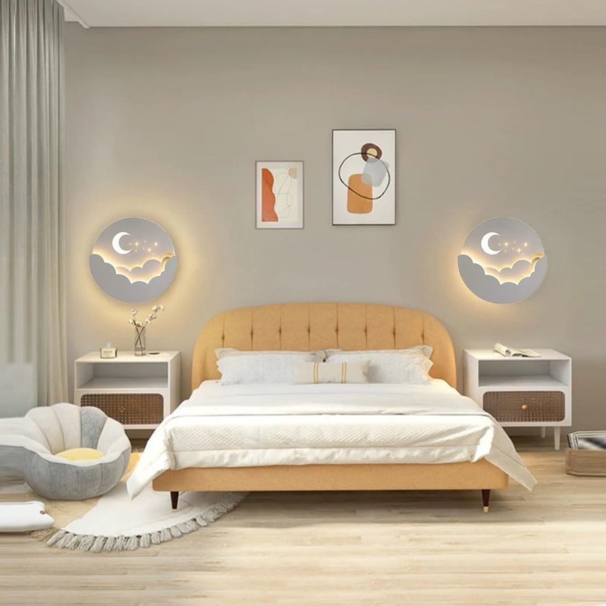 Gemütliches Schlafzimmer mit gelbem Bett, zwei Nachttischen, Wandleuchten mit Mondmotiv und zwei Bildern an der Wand.