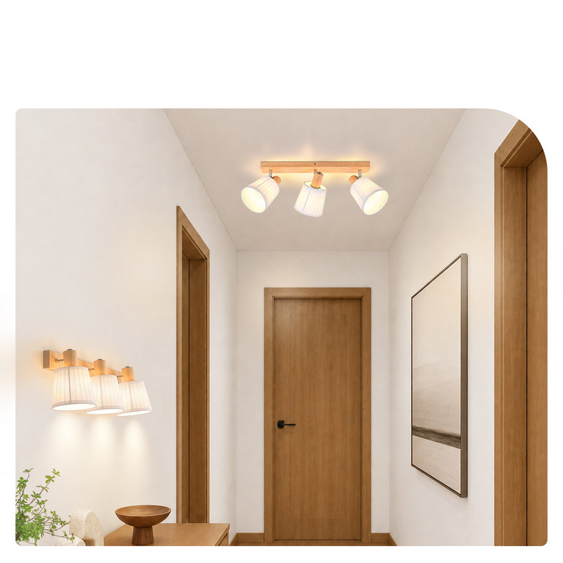 Ein heller Flur mit Holztüren, moderner Decken- und Wandbeleuchtung sowie einem gerahmten Bild an der Wand.