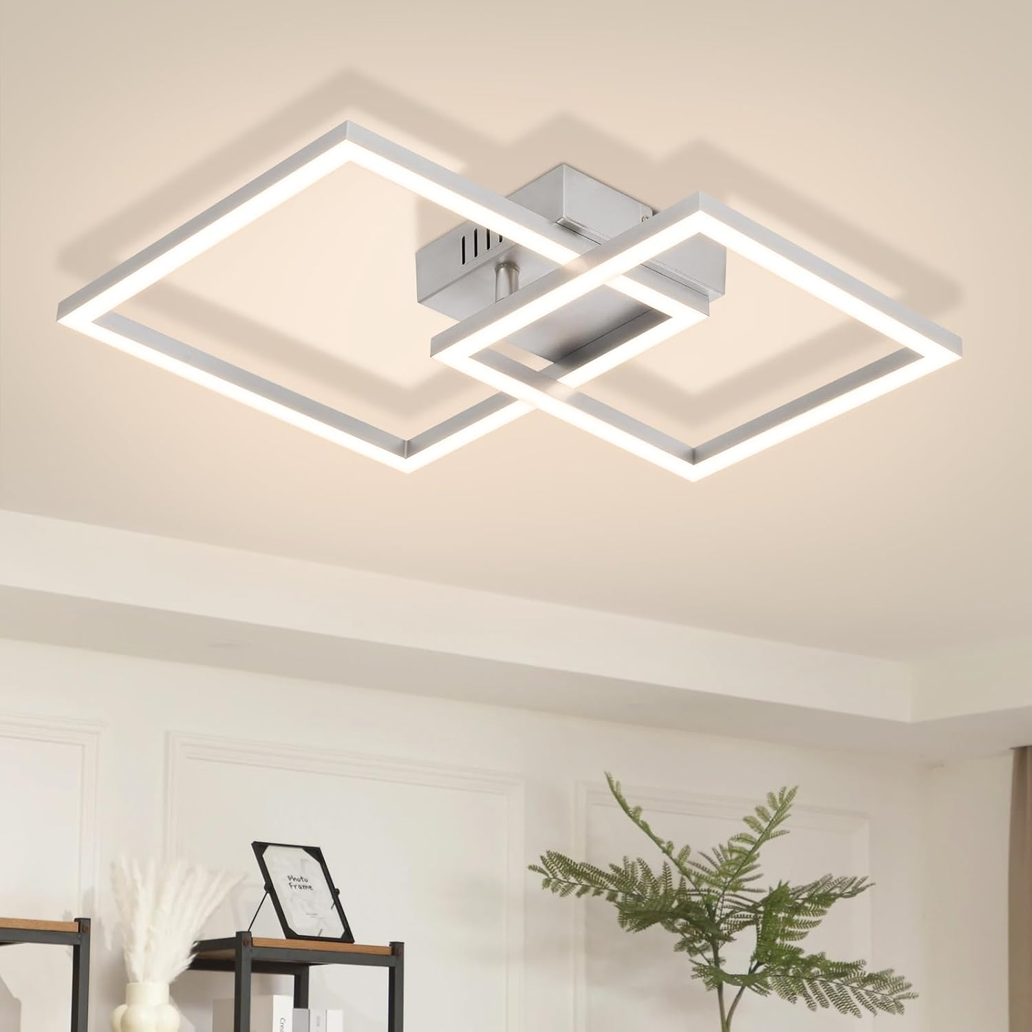 Moderne Deckenlampe mit zwei beleuchteten, verschränkten Quadraten an einer hellen Decke.