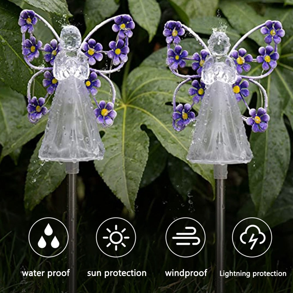 Zwei Engel-Gartenleuchten mit violetten Blumenflügeln vor grünen Blättern, mit Symbolen für Wetterfestigkeit.