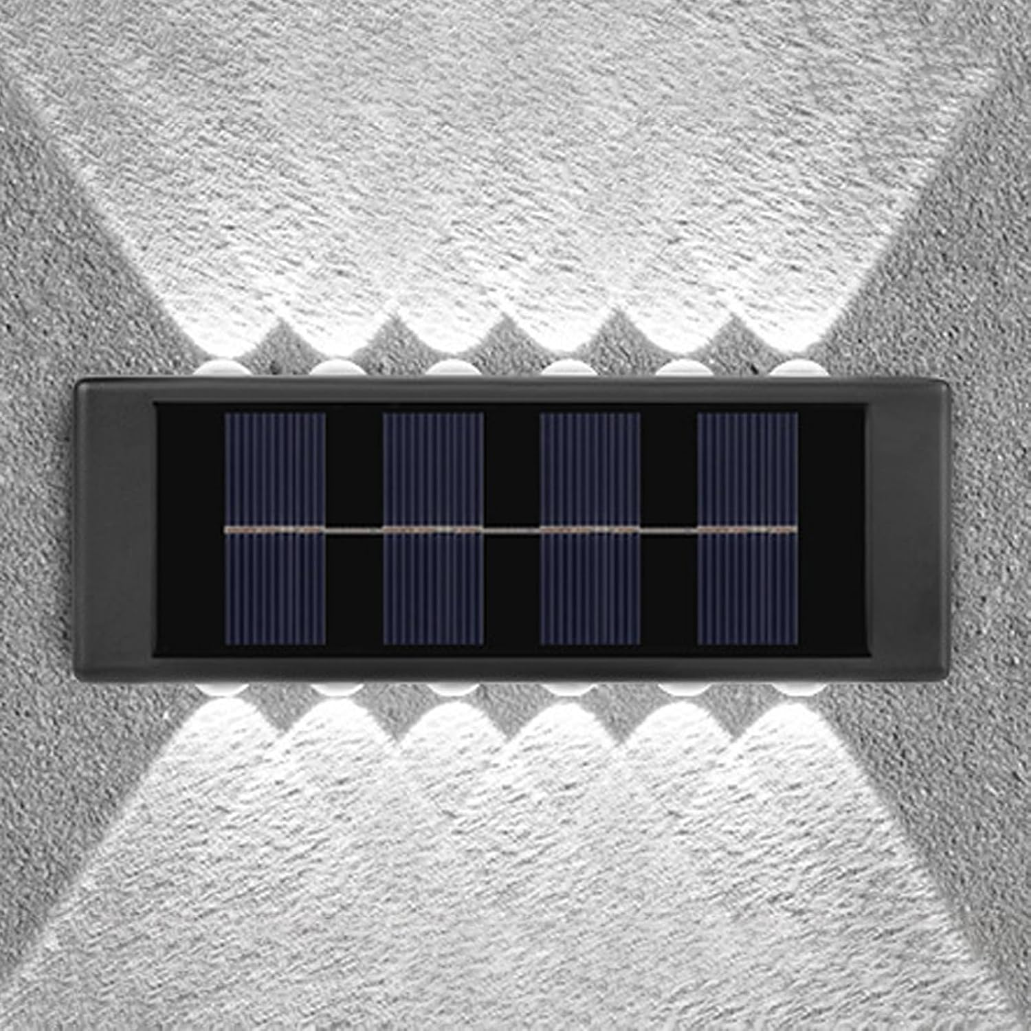 Eine schwarze Solar-Wandleuchte an einer rauen grauen Wand, die oben und unten helles Licht ausstrahlt.