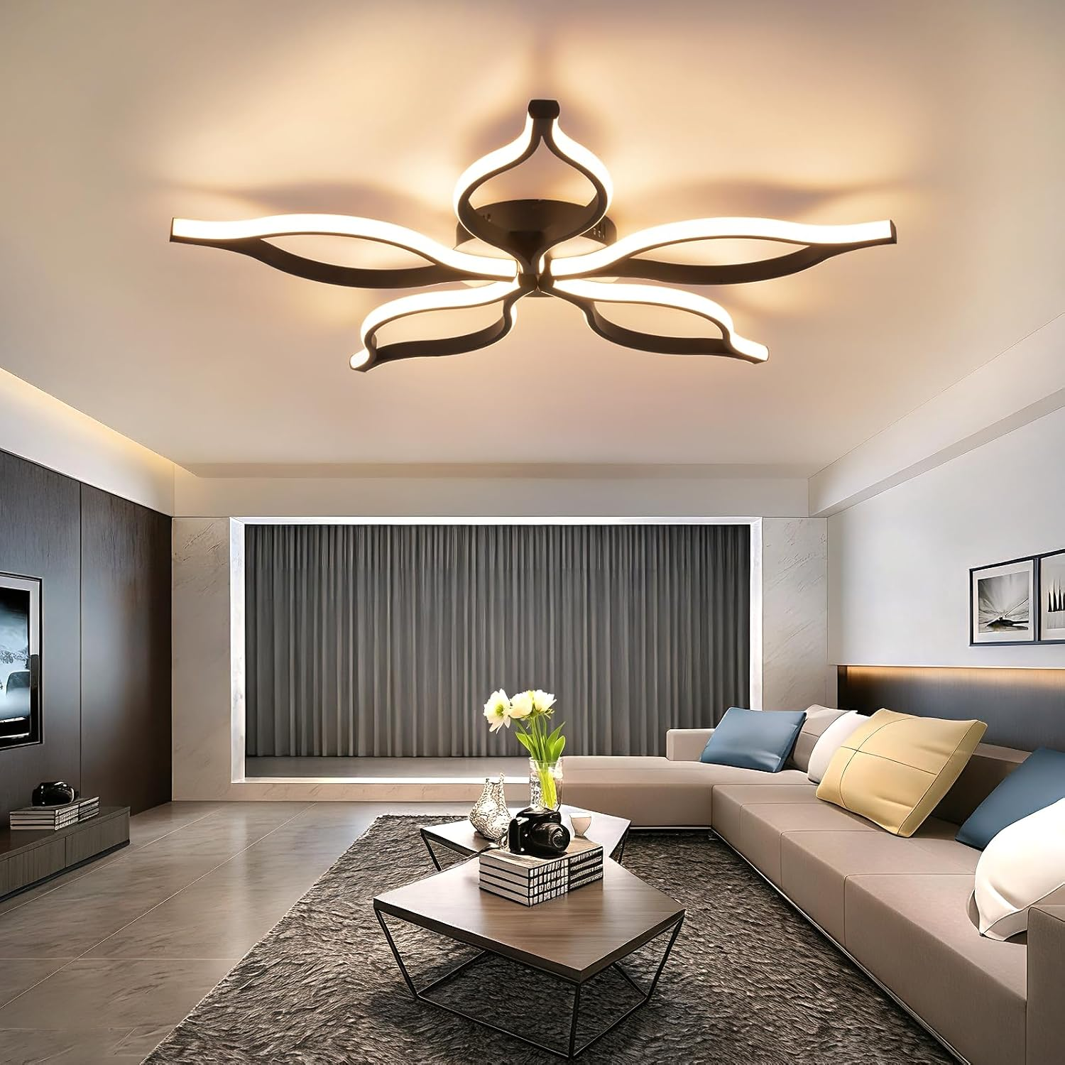 Modernes Wohnzimmer mit blumenförmiger Deckenlampe, beigem Sofa und Couchtischen auf grauem Teppich.