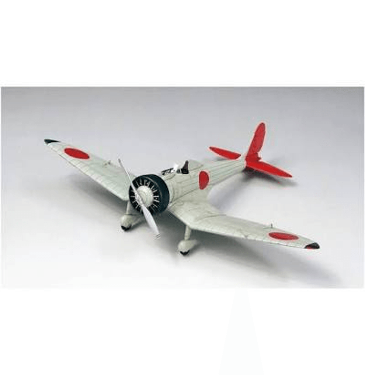 Modell eines grauen Propellerflugzeugs mit roten und weißen Markierungen auf weißem Hintergrund.