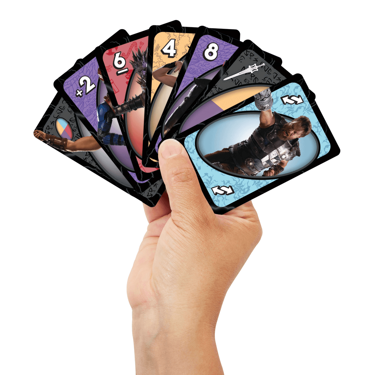 Une main tenant un éventail de cartes colorées avec des super-héros et des chiffres sur fond blanc.