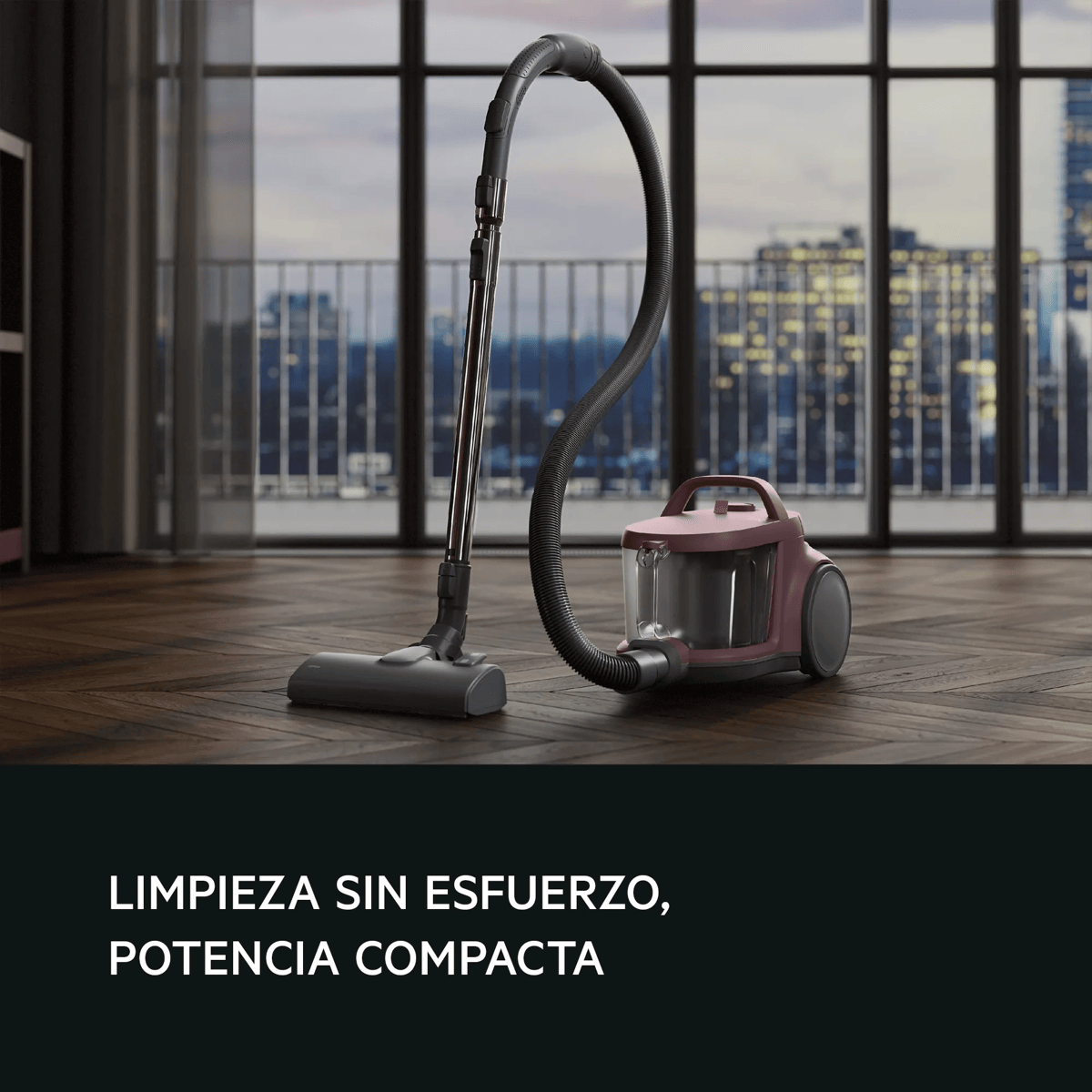 Una moderna aspiradora rosa de trineo sobre suelo de madera ante una gran ventana con vistas a la ciudad.