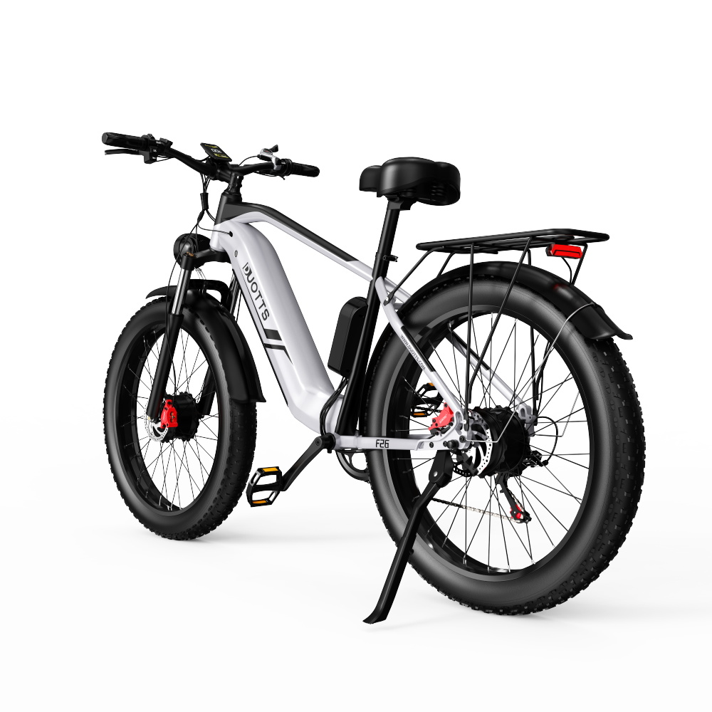 Ein weiß-schwarzes E-Fatbike mit Gepäckträger steht vor weißem Hintergrund.