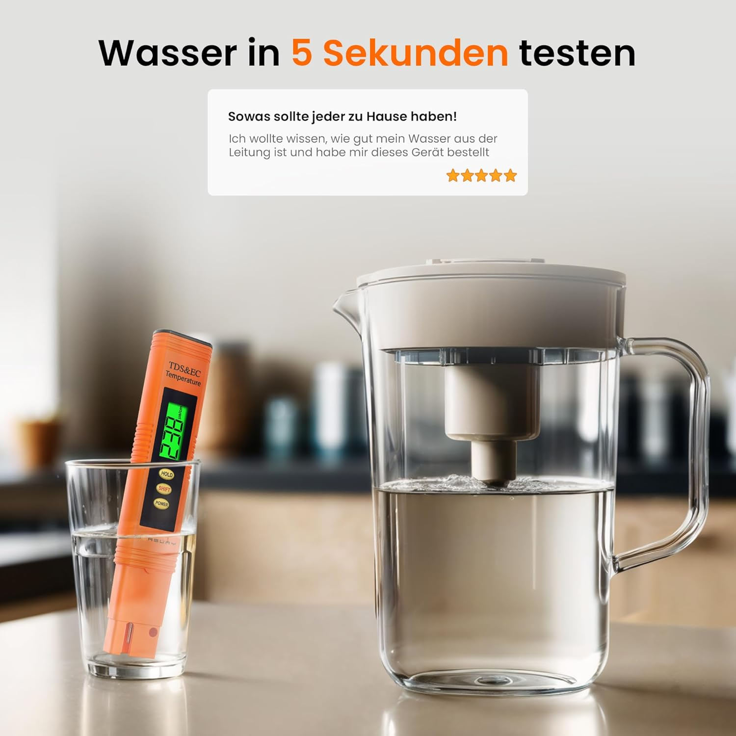 Ein TDS-Tester in einem Wasserglas und ein Wasserfilterkrug stehen auf einem Tisch in der Küche.