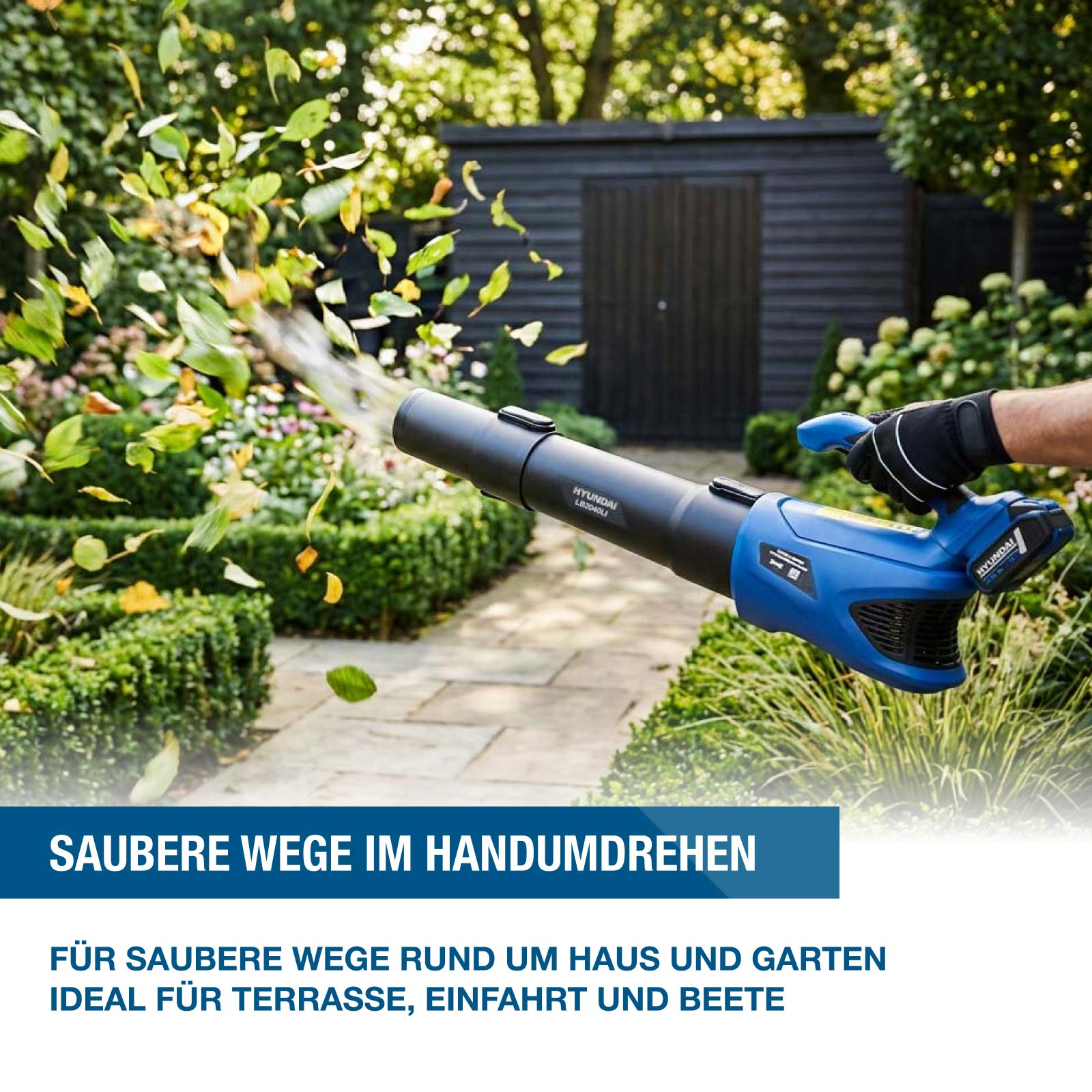 Blaues Laubgebläse bläst Blätter auf einem Gartenweg weg.
