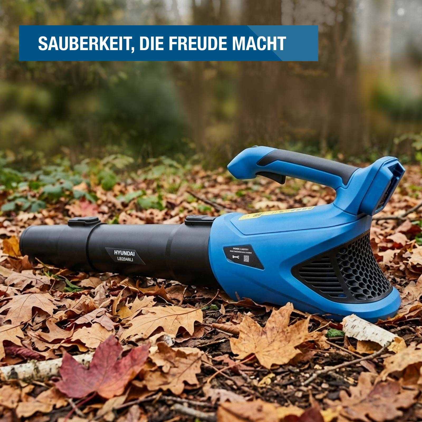 Ein blauer und schwarzer Hyundai Laubbläser liegt auf herbstlichem Waldboden voller Blätter.