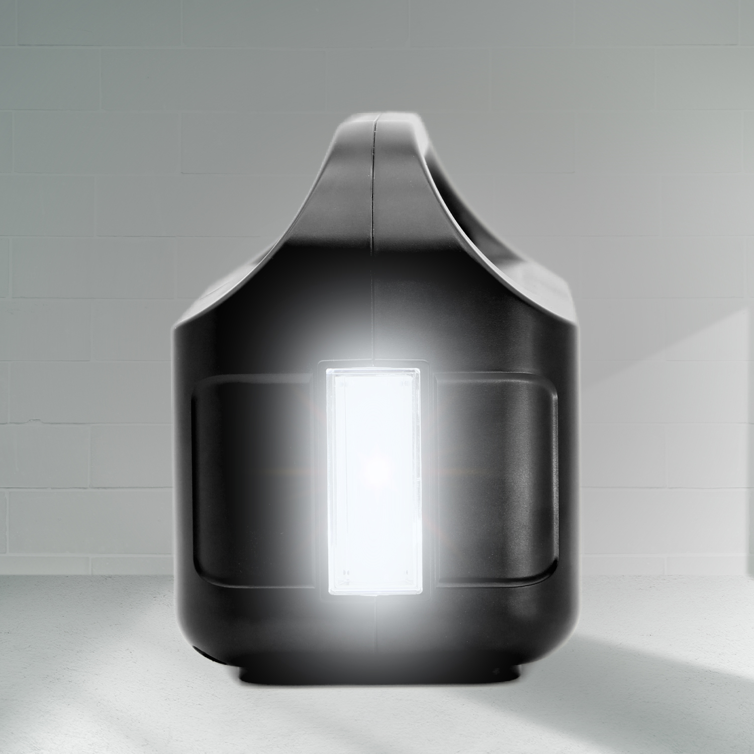 Un dispositivo portátil negro con una luz brillante en el frente se encuentra contra una pared.