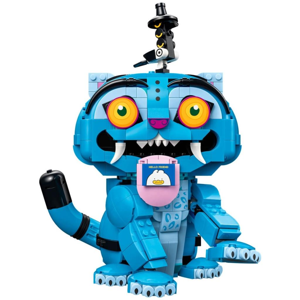 Büyük sarı gözleri, keskin beyaz dişleri ve pembe dili olan mavi bir Lego kedi yaratığı.