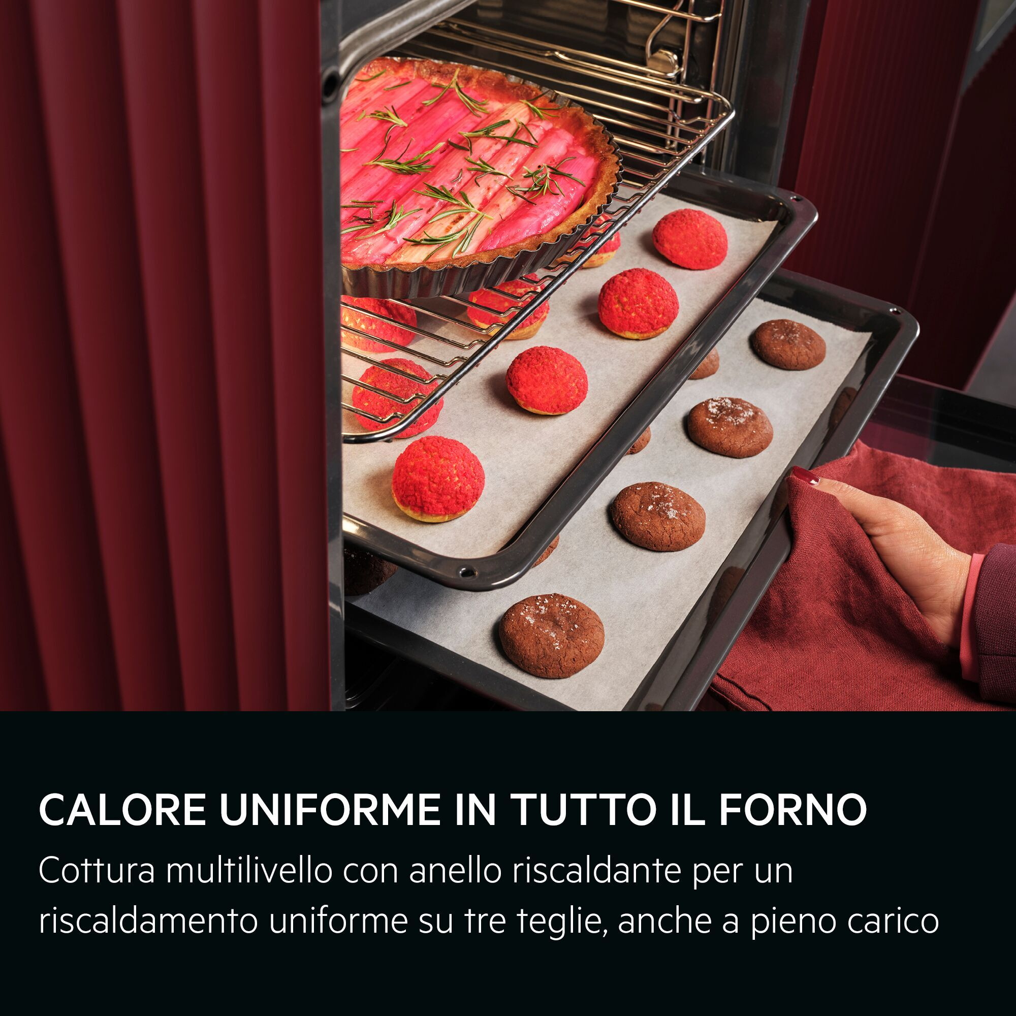 Forno con tre teglie di prodotti da forno: una torta, bignè rossi e biscotti al cioccolato.