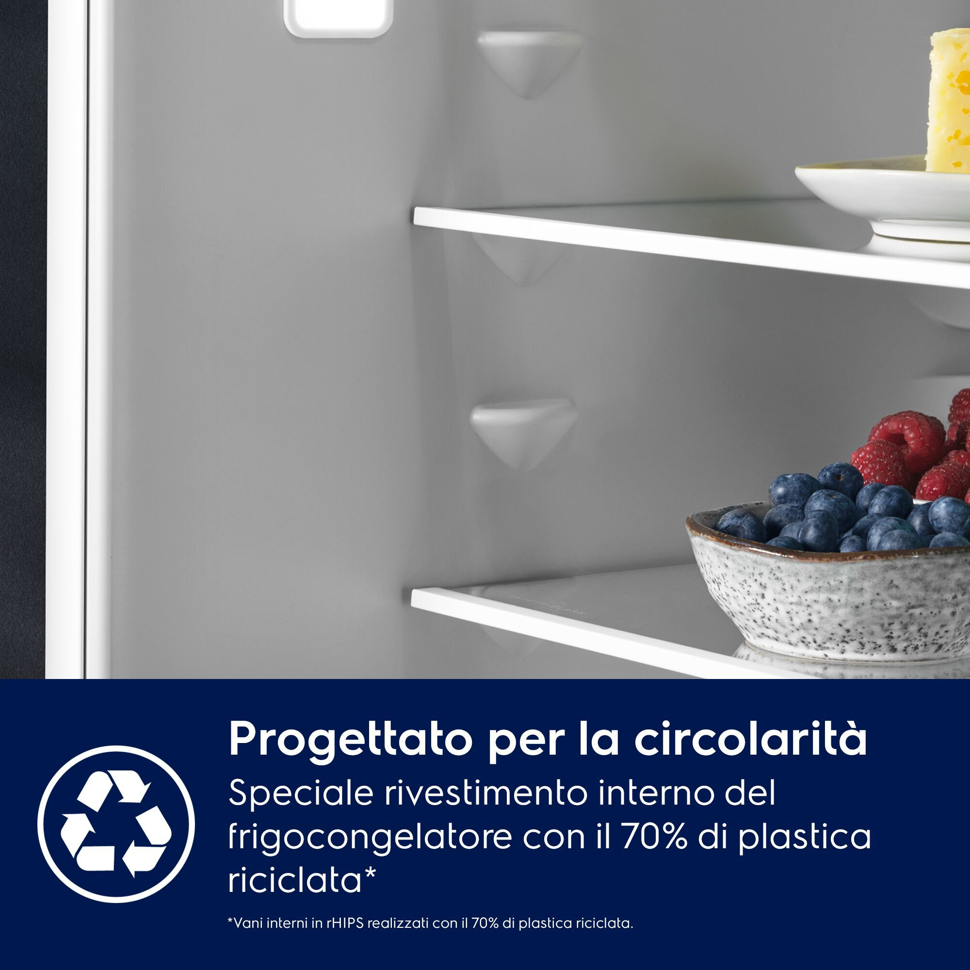 Interno frigorifero con ripiani in vetro, bacche in una ciotola e testo sulla plastica riciclata.
