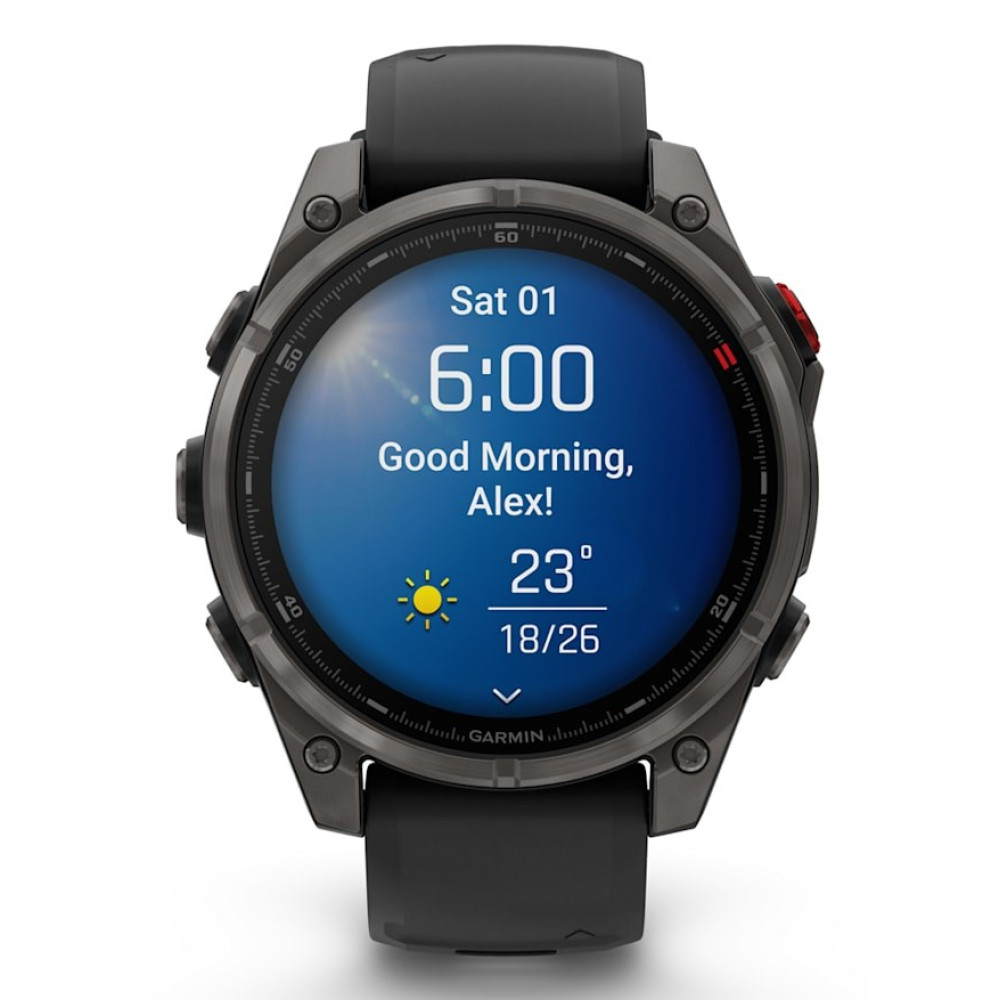 Un reloj inteligente Garmin negro con pantalla azul muestra fecha, hora, saludo y clima.