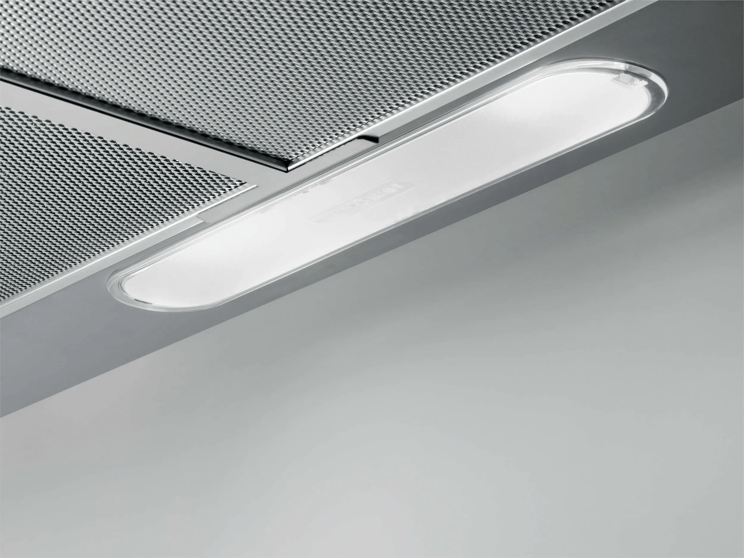 Parte inferior de una campana extractora con panel LED iluminado y filtros de grasa metálicos.