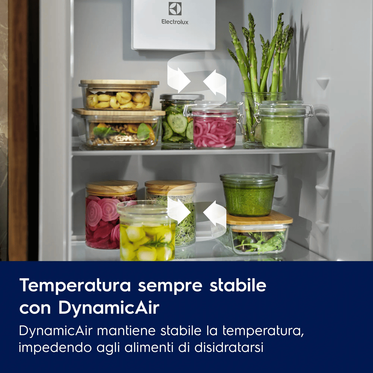 Interno di un frigorifero Electrolux pieno di contenitori in vetro con cibo e verdure fresche.