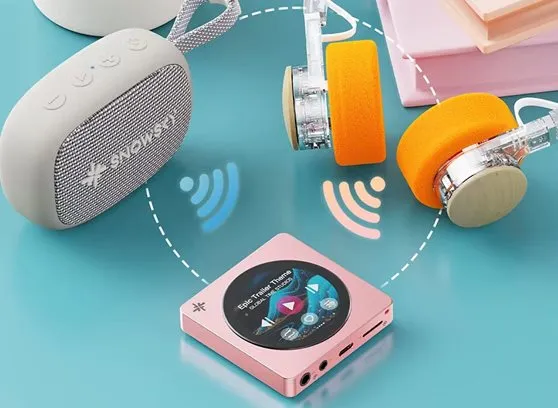 Un reproductor de música rosa se conecta de forma inalámbrica a un altavoz gris y auriculares en fondo azul.