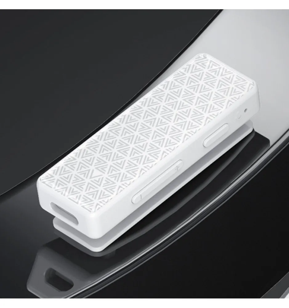 Un dispositivo blanco y rectangular con patrón geométrico sobre una superficie oscura y reflectante.
