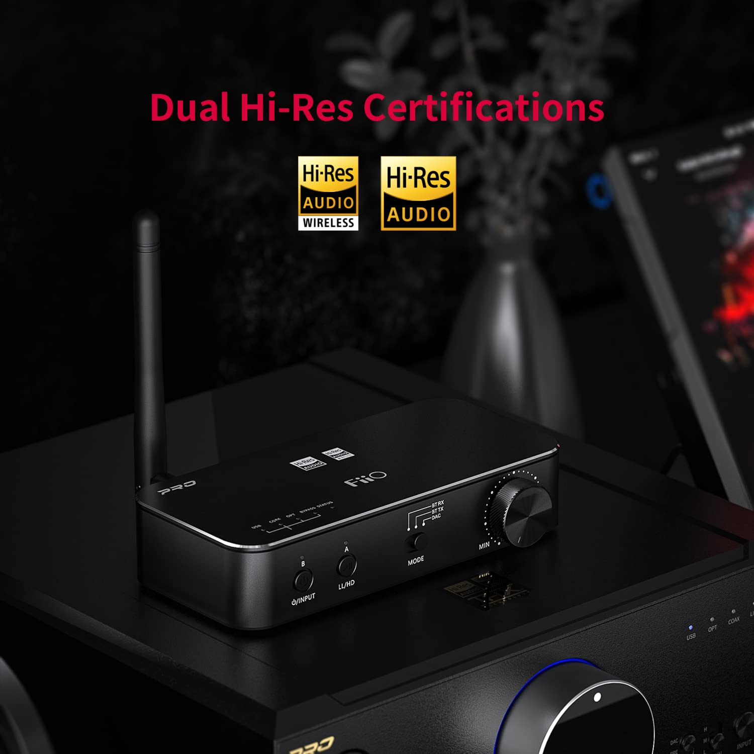 Un receptor de audio FiiO negro con antena, perilla de volumen y botones, con insignias de certificación Dual Hi-Res.