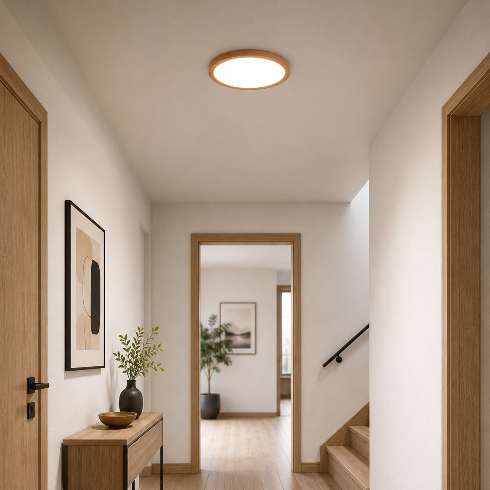 Un pasillo luminoso con marcos de madera, techo blanco, lámpara redonda y una mesa con planta.