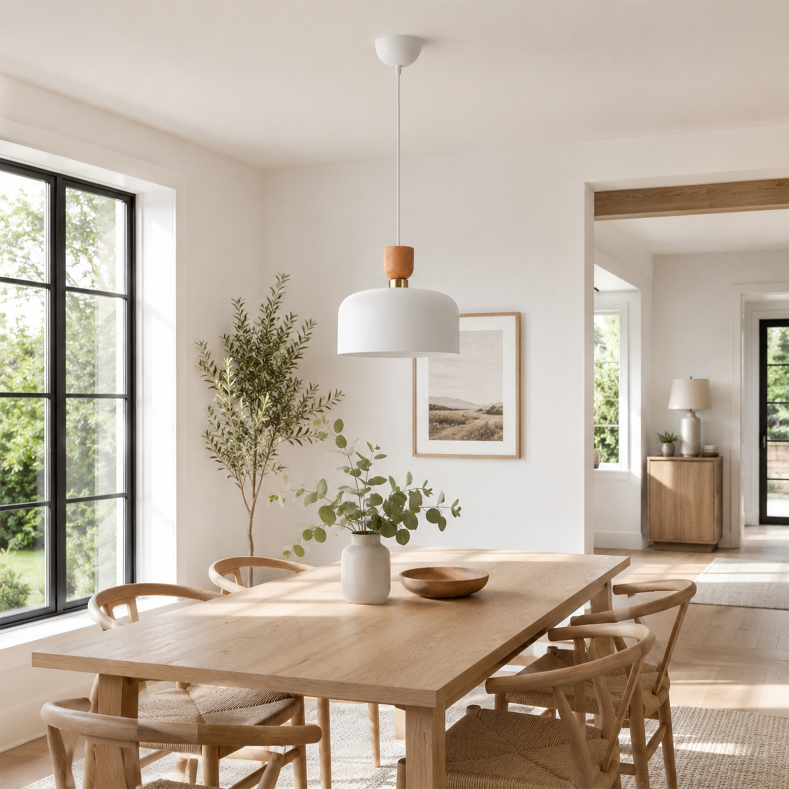 Comedor luminoso con mesa de madera, sillas, lámpara colgante y gran ventana con vista al follaje verde.