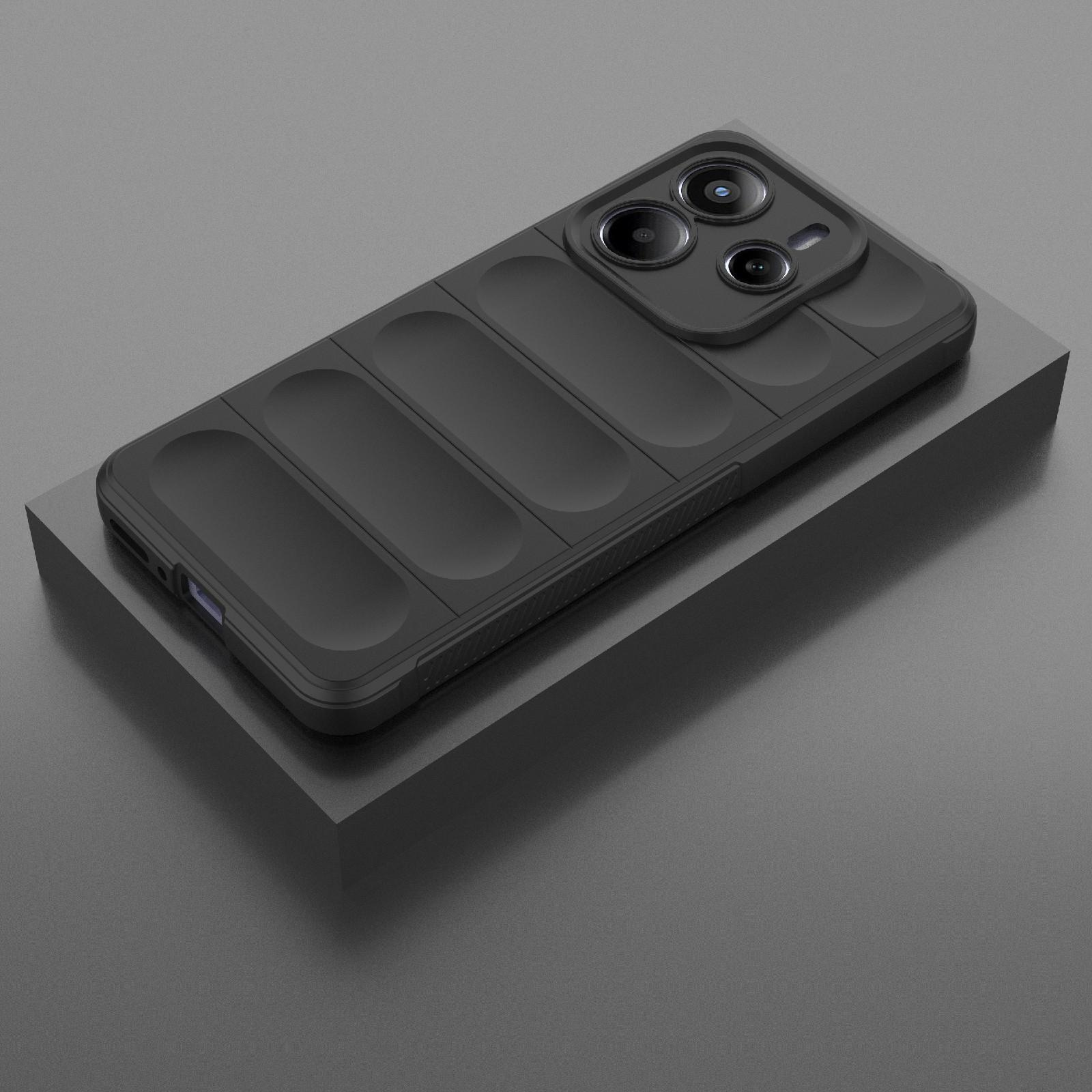 Un smartphone negro con funda protectora texturizada y módulo de triple cámara descansa sobre un bloque gris.