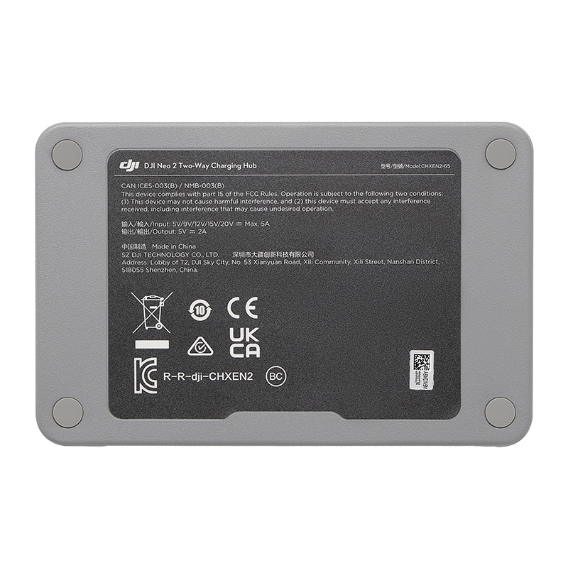 Base gris del DJI Neo 2 Two-Way Charging Hub con texto reglamentario, iconos y cuatro patas de goma.
