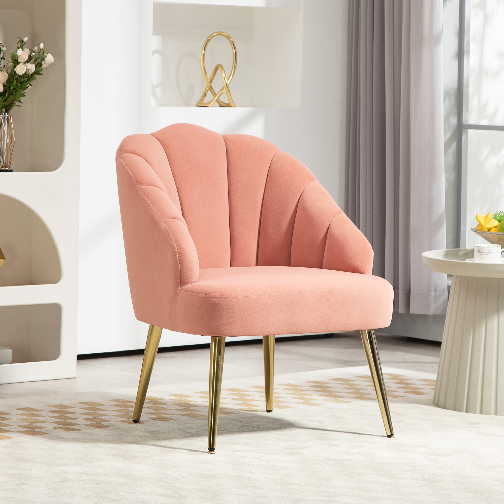Una poltrona in velluto rosa con gambe dorate in una stanza luminosa e moderna con tappeto e scaffale.