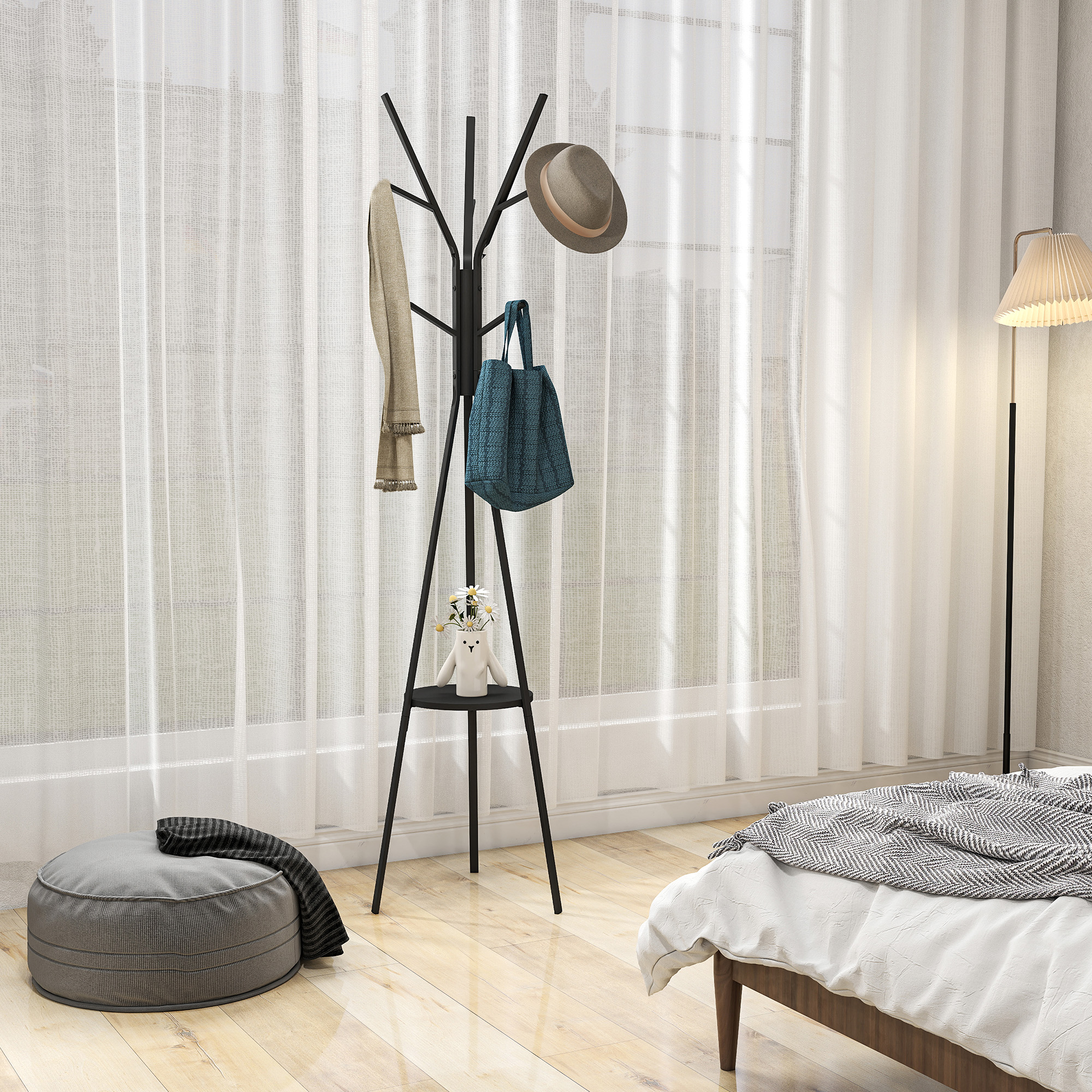 Un perchero de metal negro se encuentra en un dormitorio con cortinas claras, un puf gris y una cama.