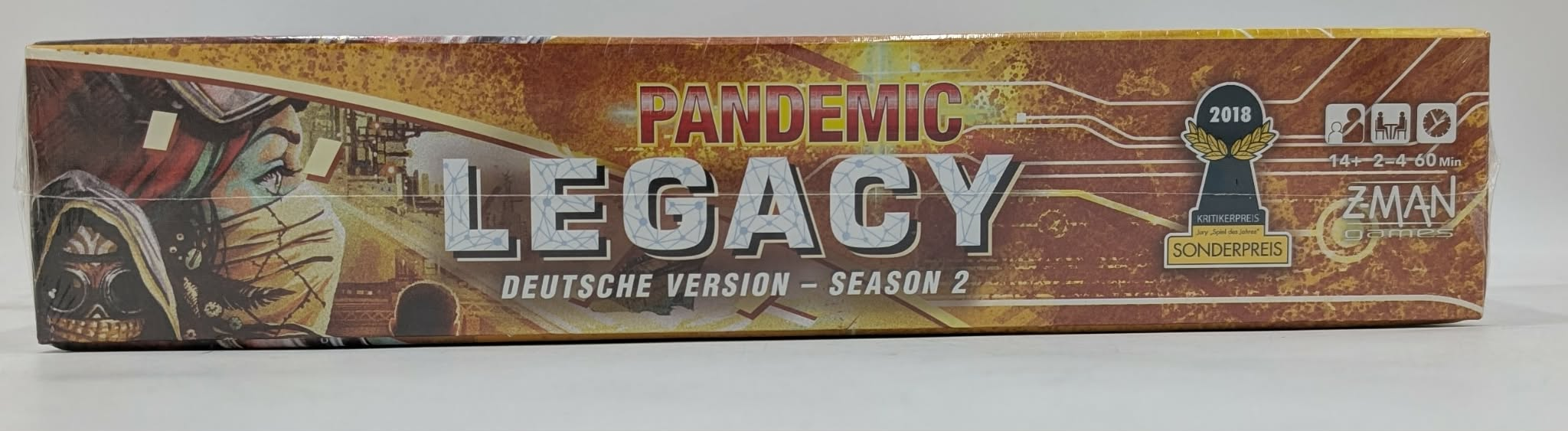 Die Seite der Pandemic Legacy Season 2-Spielschachtel mit dem Titel in fetten Buchstaben vor gelbem Hintergrund.