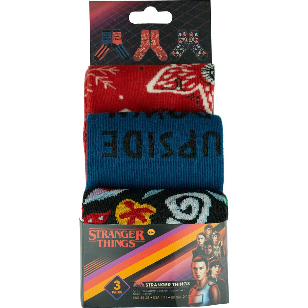 Un paquete de tres pares de calcetines de Stranger Things en rojo, azul y negro con diseños de la serie.