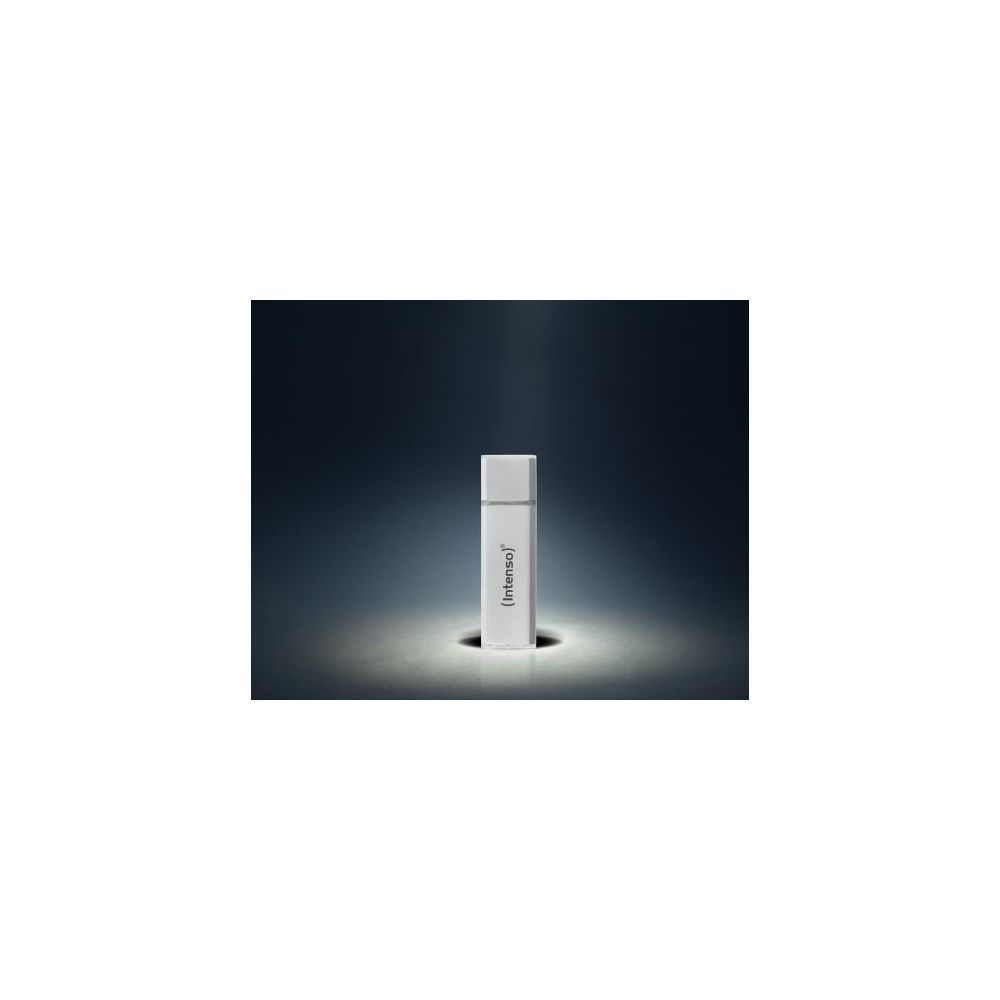 Una memoria USB blanca de Intenso se encuentra verticalmente en una superficie oscura iluminada con fondo oscuro.