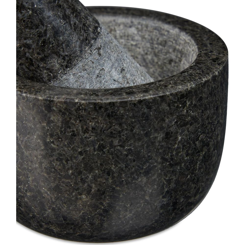 Eine Nahaufnahme eines dunkelgrauen Mörsers und Stößels aus Granit.