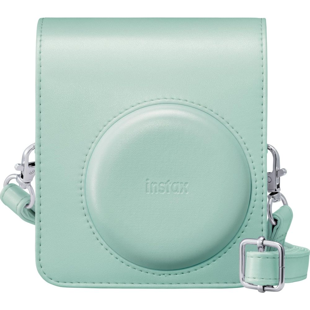 Estuche para cámara Instax verde menta con tapa redonda para lente, herrajes plateados y correa en fondo blanco.