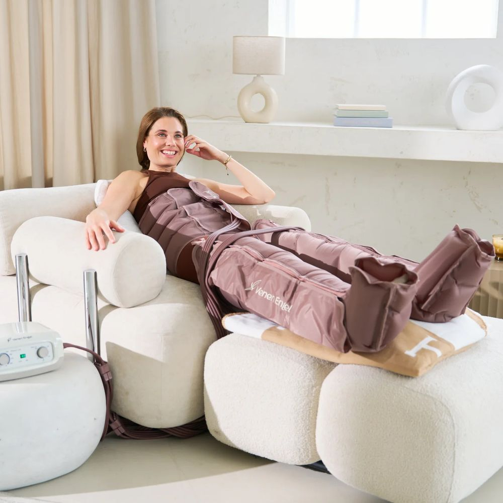 Une femme se détend dans un fauteuil moderne en portant des bottes de compression grises.